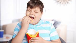 An obese child is having french fries