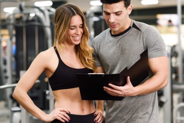 Trainer assess muscle quality of gym member