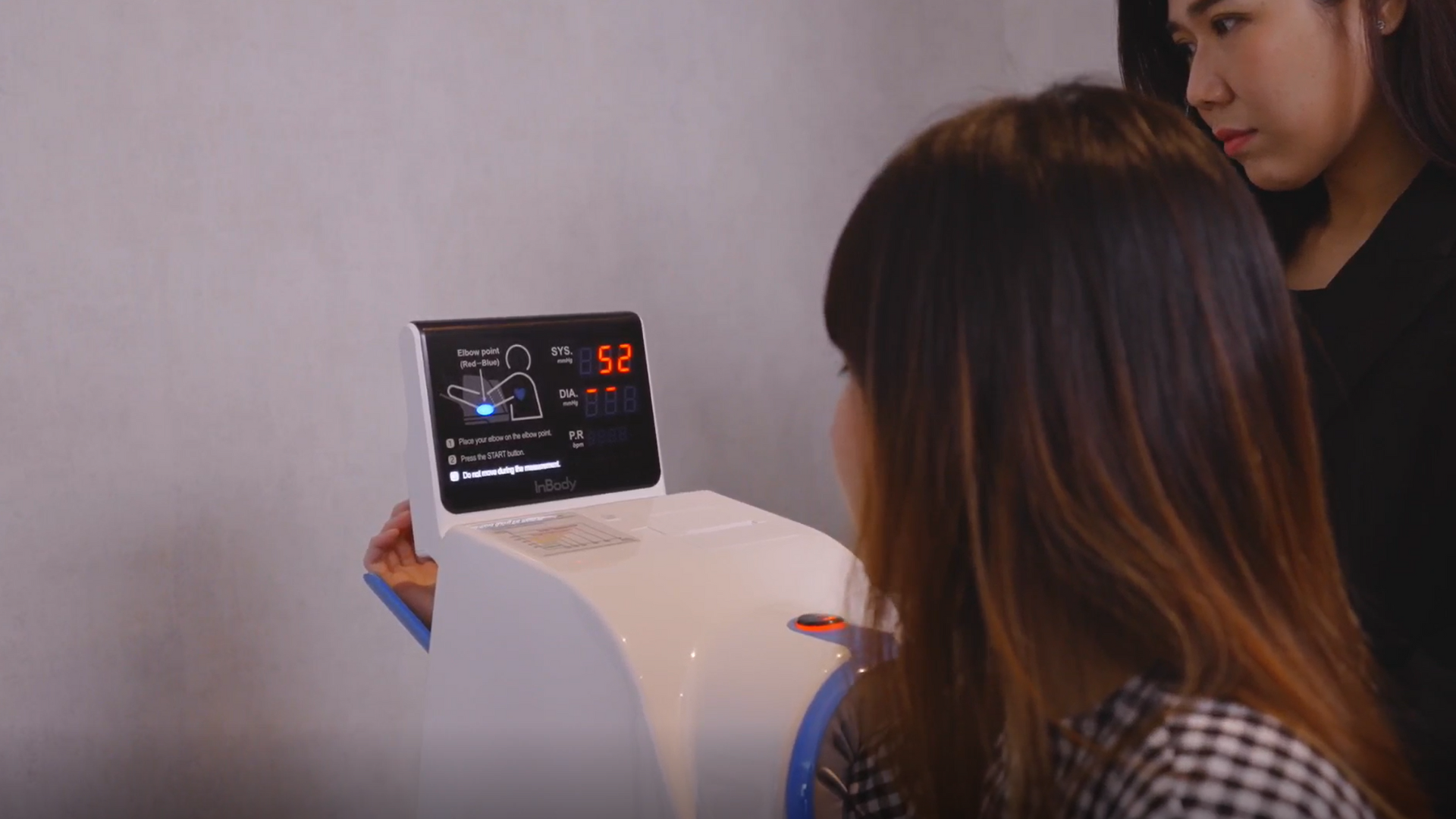 Doctor assisting client to measure blood pressure using the InBody BPBIO750