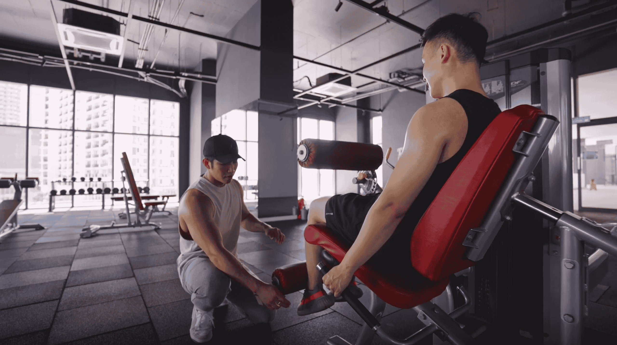 Trainer assisting and guiding his client in training at the gym