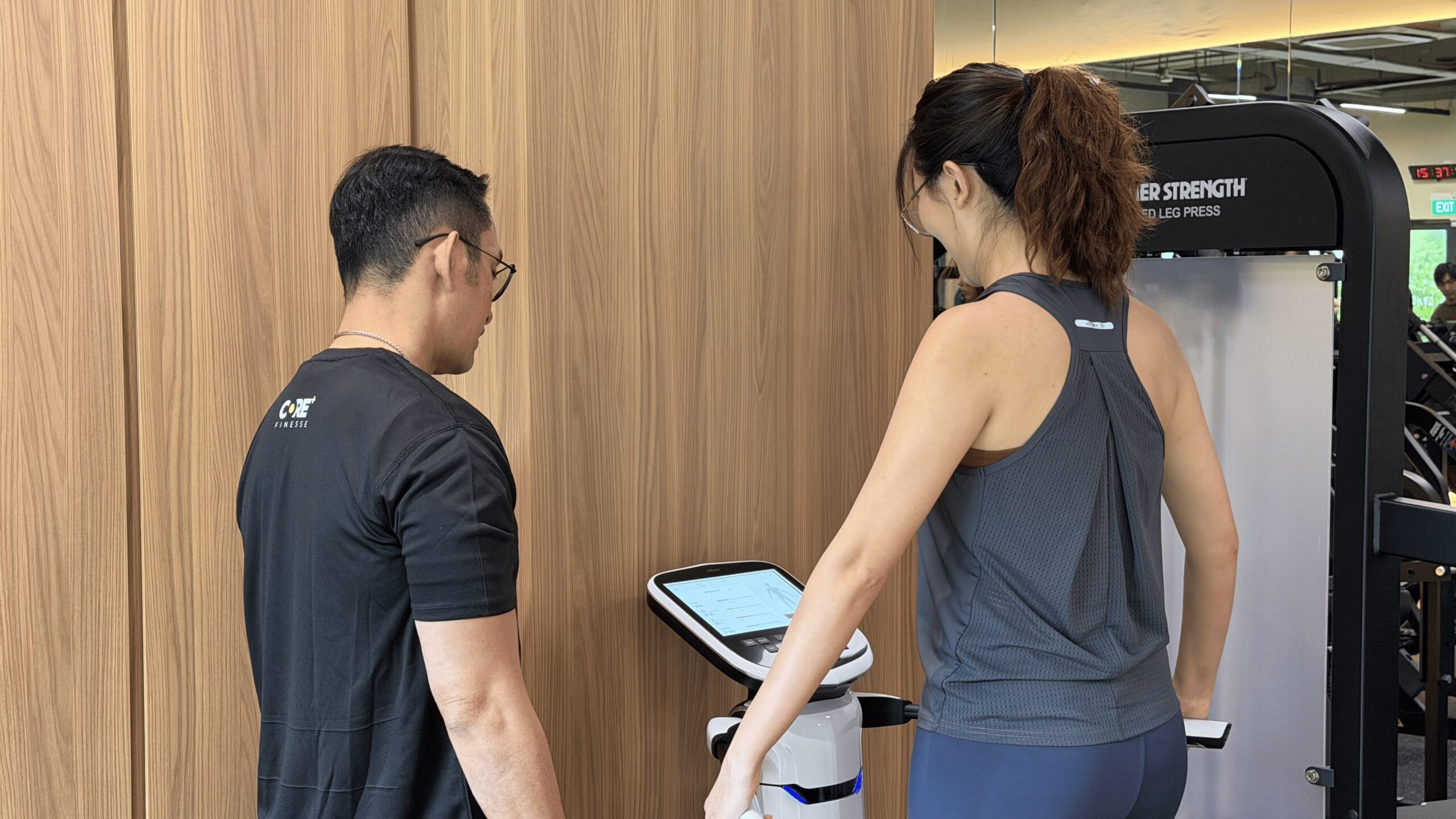 Pilates instructor assisting client on doing an InBody test
