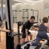 Pilates instructor guiding client on doing lunges on a reformer
