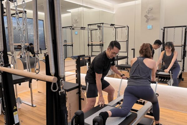 Pilates instructor guiding client on doing lunges on a reformer