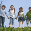 Children holding hands and happily laughing on a field